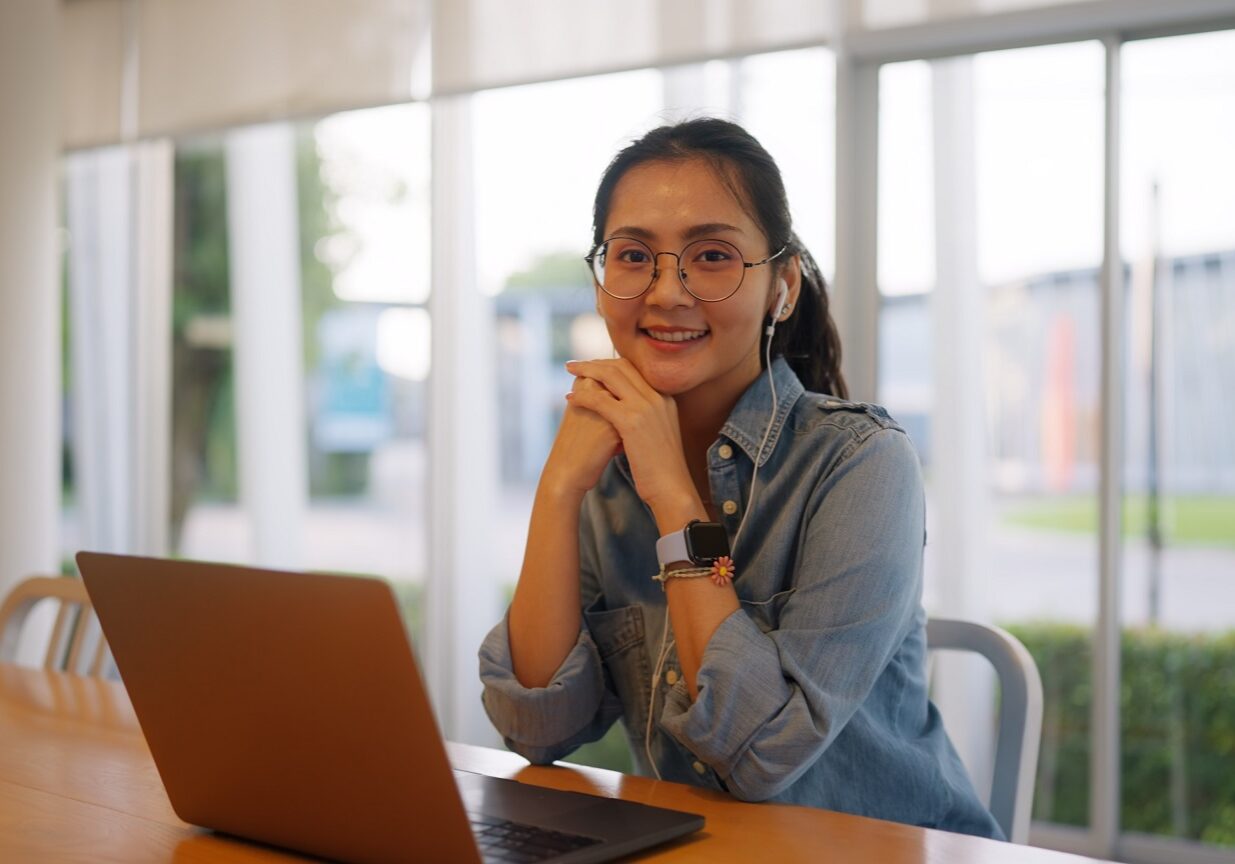 Asia young casual people teen girl woman look at camera sit relax smile work anywhere workation at table cafe coffee shop workspace self study MBA lesson reskill career upskill job hybrid workforce. Altura Learning aged care training Australia education Bridge LMS