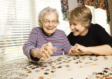 Elderly Woman and Younger Woman Doing Puzzle Elderly Woman and Younger Woman Doing Puzzle