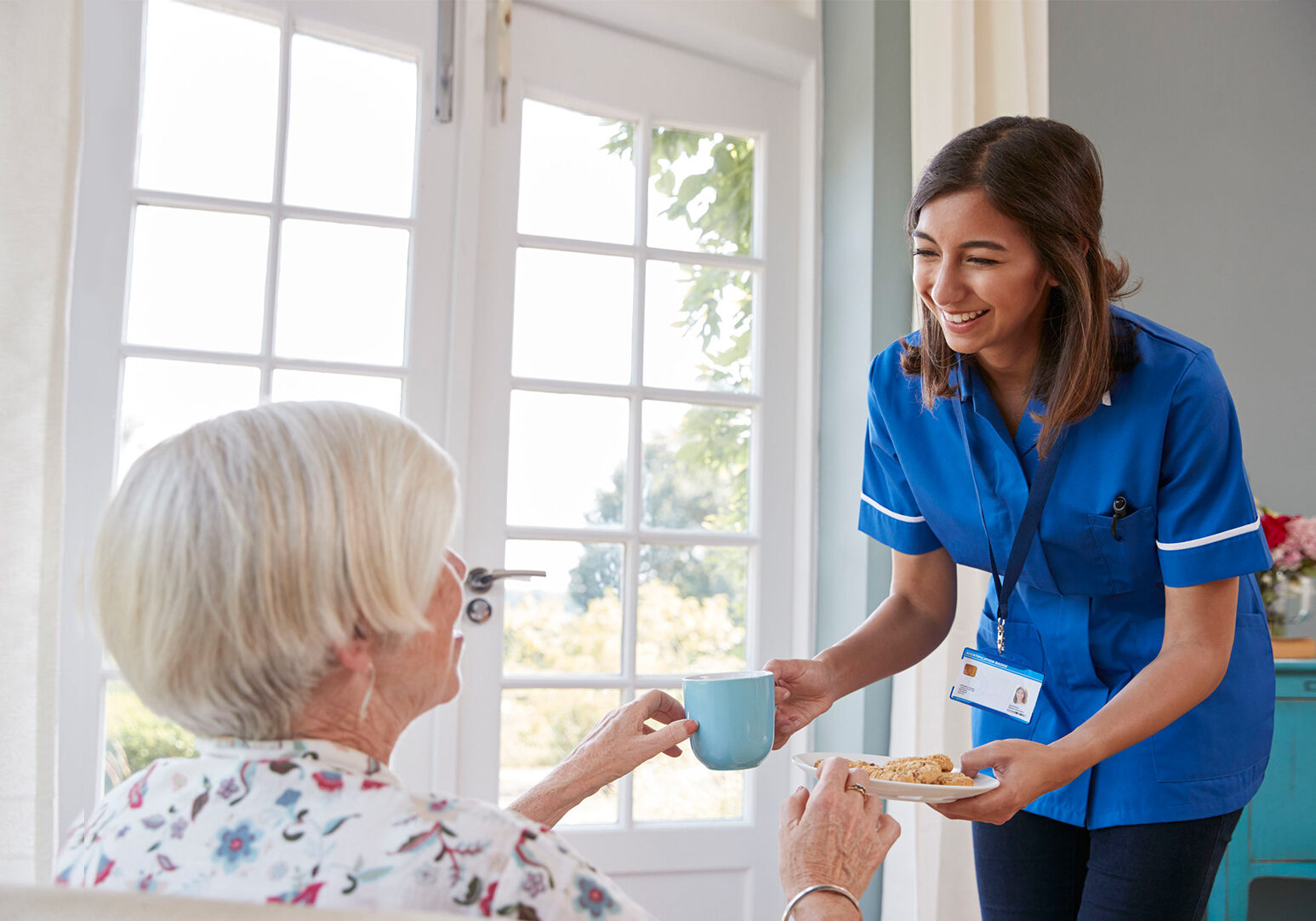 altura-learning-aged-care-training Nurse providing elderly women with tea and cakes