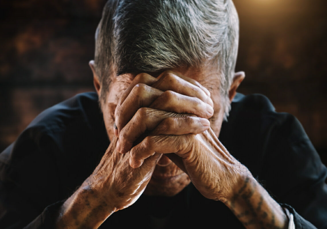 senior man covering his face with his hands.vintage tone Caring for patients with schizophrenia